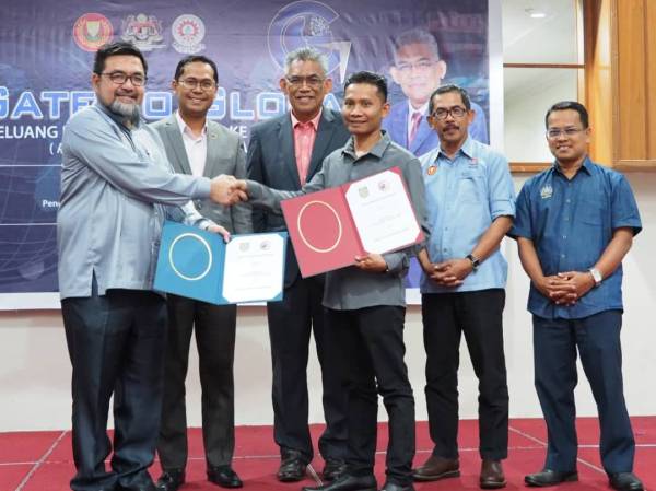 Jamal (kiri) bertukar dokumen perjanjian persefahaman dengan wakil Iman Kasih Sdn Bhd sambil disaksikan Dr Ismail (tiga dari kiri), Mohd Asmirul (dua dari kiri) dan Yahaya (dua dari kanan).