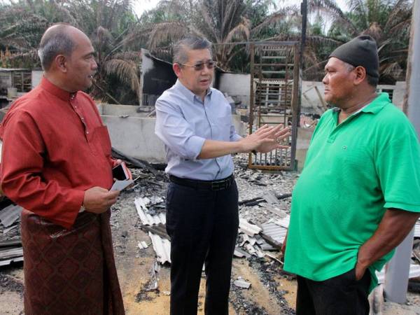 Menteri Pertanian dan Industri Asas Tani, Datuk Seri Salahuddin Ayub (tengah) bersama Ketua Pengarah Lembaga Kemajuan Ikan Malaysia, Jamaludin Bin Othman (kiri) beramah mesra dengan Abdul Razak Sahak, 60, ketika menyerahkan surat kelulusan bantuan program bina baharu menerusi Projek Khas Perumahan Nelayan (PKPN) di kediamannya di Jalan Benting Dinding, Tanjung Piai hari ini. - Foto Bernama