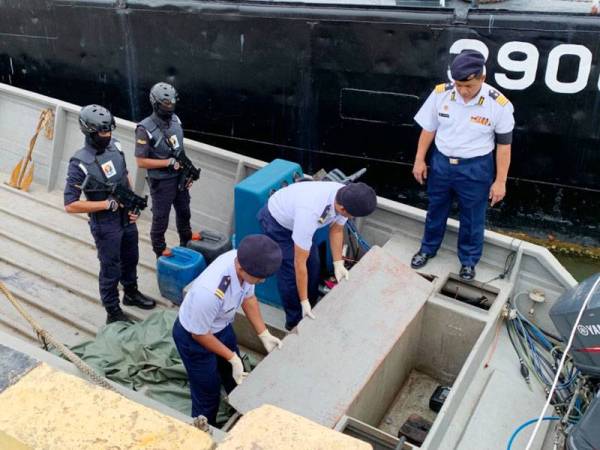 Muhammad (kanan) melihat tempat menyimpan sebahagian daripada gelen petrol yang dirampas.