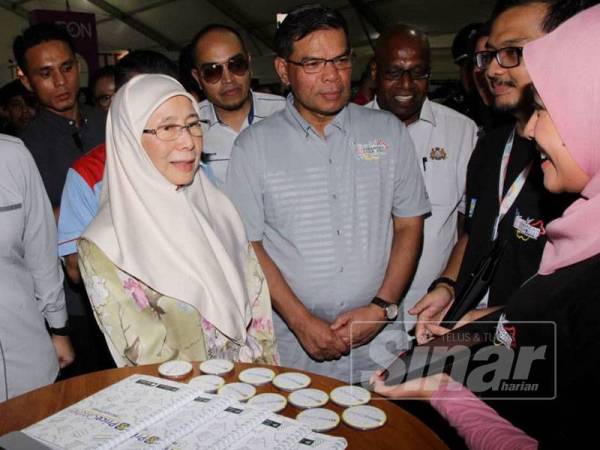 Wan Azizah (kiri) beramah mesra dengan seorang pempamer yang menjayakan Karnival Kempen Beli Barangan Malaysia Peringkat Kebangsaan di Dataran Angsana, Johor Bahru.