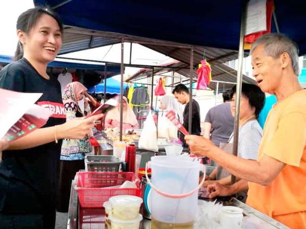 Wendy menyantuni orang ramai pada program walkabout calon-calon PRK Tanjung Piai di Pasar Pagi Pekan Nanas hari ini.