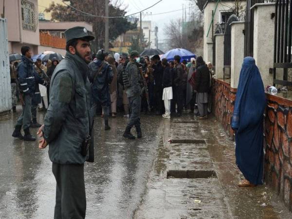 Polis Afghanistan mengawal orang ramai yang beratur di luar Kedutaan Pakistan di Kabul. - Foto: AFP