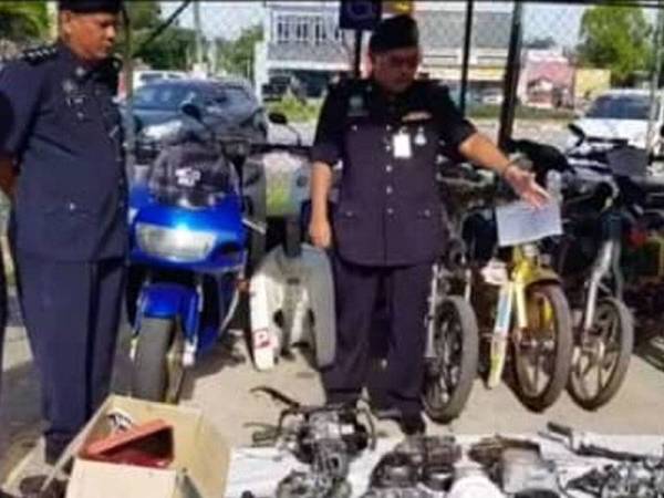 Abdul Rozak (kanan) menunjukkan sebahagian daripada komponen motosikal yang dirampas dalam serbuan di sebuah bengkel motosikal di Kampung Bukit Kenak, Jertih, Besut, Khamis lalu.