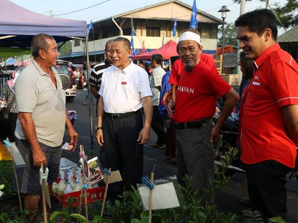 Karmaine (dua dari kiri) bersama Timbalan Menteri Hal Ehwal Ekonomi, Dr Mohd Radzi Md Jidin (kanan) beramah mesra dengan para peniaga Pasar Pagi Pekan Serkat Laut bagi kempen PRK Parlimen Tanjung Piai hari ini. - Foto Bernama