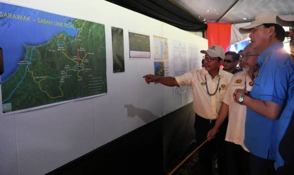 Baru(kanan) diberi taklimat tentang projek jajaran Sarawak-Sabah Link Road (SSLR) di hujung Jalan Long Sebangang-Bukit Berikau Lawas pada majlis pelancaran pembinaan jalan itu hari ini. -Foto Bernama