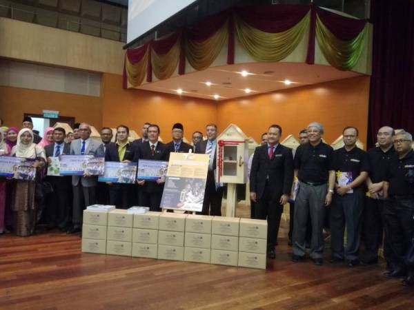 Mohd Cairul Iqbal (lima dari kanan) bersama wakil sekolah terlibat yang menerima sumbangan sudut bacaan.