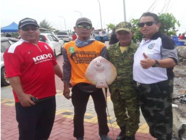 Dr Ammar (kanan) bersama pemancing yang menaikkan ikan pari di Tambak Pontian pada tahun lalu.