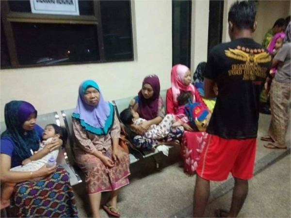 Norizan (dua dari kiri) bersama anak dan penduduk Kampung Tanah Putih yang dipindahkan ke PPS semalam.