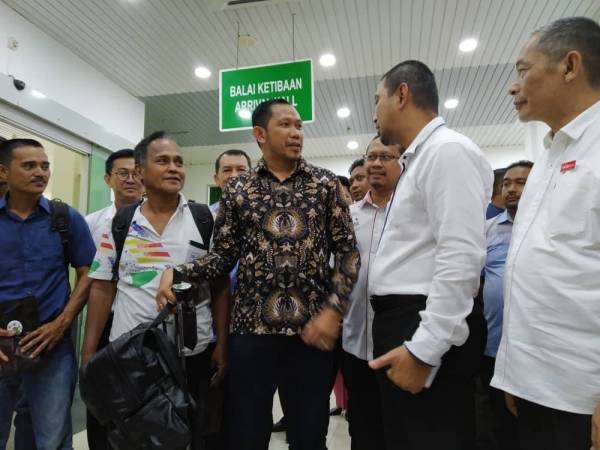 Sahruddin (dua dari kanan) beramah mesra dengan penumpang feri dari Tanjung Balai Indonesia yang tiba di Terminal Feri Antarabangsa Kukup di sini hari ini.