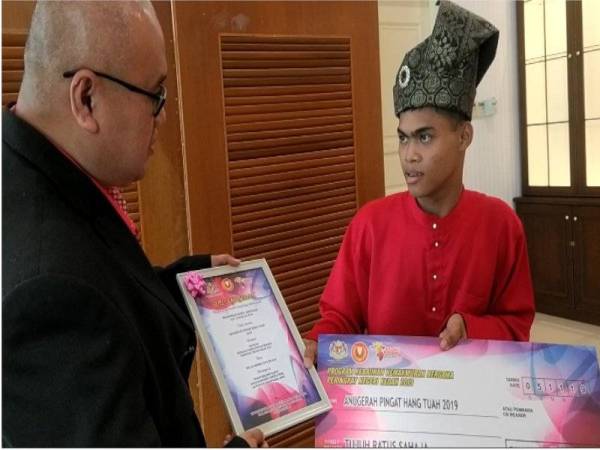 Pegawai Jabatan Kebajikan Masyarakat (JKM) Daerah Baling, Shamsul Izrin Isahak berbual dengan Muhammad Rasul yang menerima Pingat Hang Tuah 2019 pada Program Kebajikan Kemakmuran bersama Peringkat Negeri Kedah 2019 di Dewan Seri Mentaloon di sini baru-baru ini.