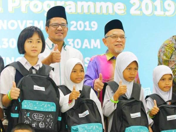 Wan Mohd Hasnan (belakang, kiri) bersama Hanifa (belakang, kanan) bersama murid-murid yang menerima sumbangan pada Program BTS 2019.