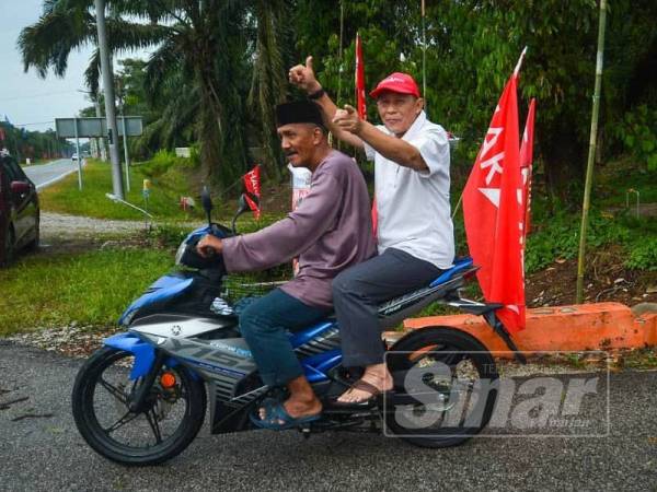 Karmaine membonceng motosikal ketika berkempen di Kampung Tengah Dua, Pontian hari ini. - FOTO SHARIFUDIN ABDUL RAHIM