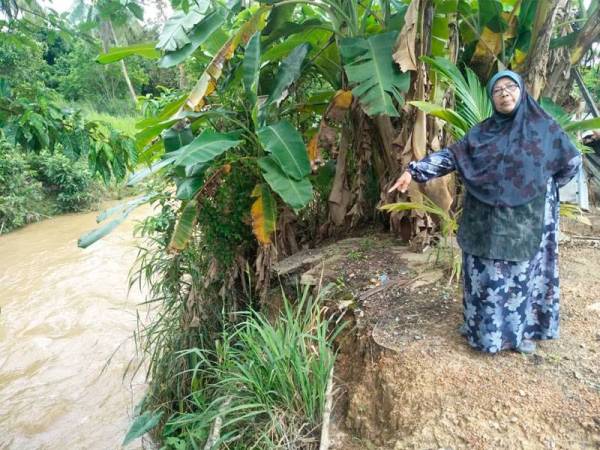 Fadhiah menunjukkan tebing sungai yang semakin menghakis