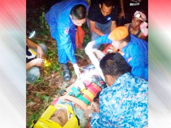 Anggota APM berusaha membawa mangsa keluar dari kawasan kebun untuk mendapatkan rawatan di hospital.