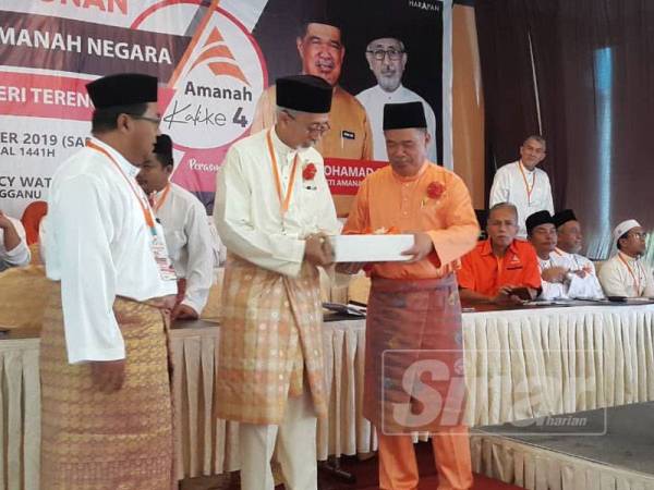 Raja Kamarul Bahrin (tengah) menyampaikan cenderahati kepada Mohamad Sabu selepas perasmian Konvensyen Tahunan Amanah Terengganu di The Regency Waterfront Hotel di sini hari ini.