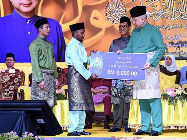 Sultan Nazrin Shah berkenan menyampaikan Anugerah Pendakwah kepada Arifin Long Chor (dua dari kiri) pada Majlis Sambutan Maulidur Rasul Negeri Perak di Pusat Konvensyen Casuarina hari ini. - Foto Bernama