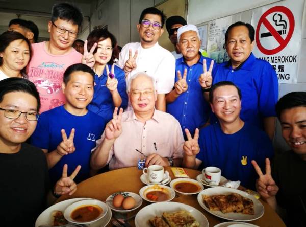 Jeck Seng (duduk, dua dari kanan) bersama Penasihat BN, Datuk Seri Najib Tun Razak, pimpinan BN Johor serta pengunjung restoran ketika bersarapan di Restoran Kheng Guan Hiong berhampiran Pasar Awam Pontian pagi tadi.