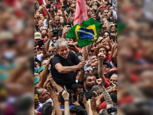 Bekas presiden Brazil, Luiz Inacio Lula da Silva (Lula) mengibarkan bendera Brazil ketika diusung penyokong setianya dalam perhimpunan di Sao Bernardo do Campo semalam. - Foto AFP