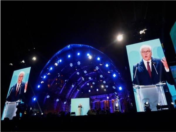 Presiden Jerman Frank-Walter Steinmeier bercakap ketika sambutan ulang tahun ke-30 runtuhnya Tembok Berlin di Brandenburg Gate semalam. - Foto AFP