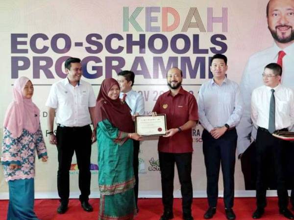 Mukhriz (tiga dari kanan) menyerahkan sijil penyertaan kepada wakil sekolah terlibat yang menjayakan program ‘Eco-Schools’.