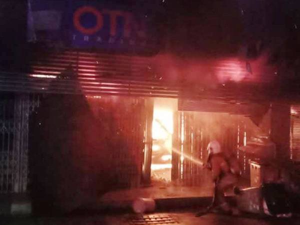 Anggota bomba memadam kebakaran dua buah kedai di Jalan Abdullah, Segamat malam tadi. Foto: JBPM