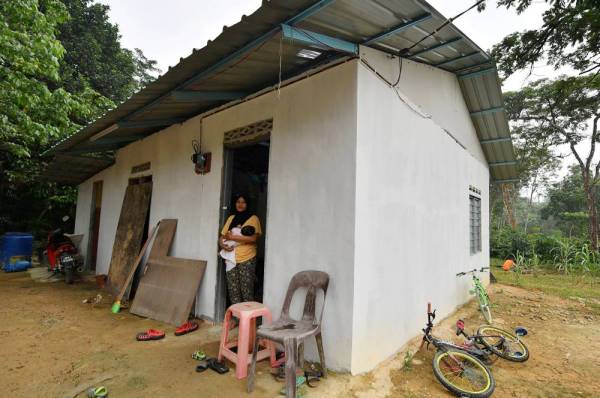 PNorhaslinda Abdul Rahman 33, bersama anaknya Nurul Nadiah Humairah, 48 hari di hadapan rumah mereka di Kampung Maju Jaya di sini. - Foto Bernama