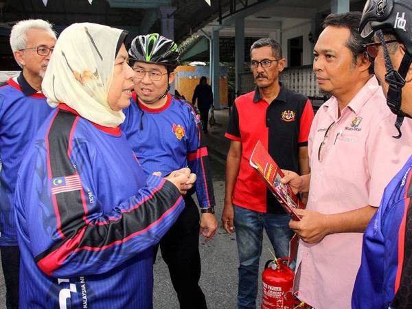 Menteri Perumahan dan Kerajaan Tempatan Zuraida Kamaruddin (kiri) berbual bersama Pegawai Khas Penyelaras Dun Kukup, Md Hafizuddin Mohd Salleh (dua dari kanan) pada Program Kayuhan Bomba Komuniti di kawasan Tanjung Piai, hari ini. - Foto Bernama