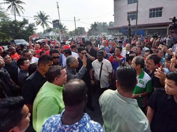 Dr Mahathir melambaikan tangan kepada orang ramai ketika hadir untuk bersarapan pagi bersama Badan-Badan Bukan Kerajaan (NGO) Pontian di Pekan Nanas hari ini. - Foto Bernama