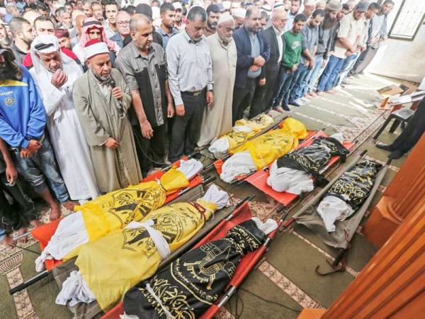 Penduduk Palestin menunaikan solat jenazah lapan sekeluarga yang terbunuh dalam serangan udara dilancarkan Israel di Deir al-Balah di selatan Gaza.