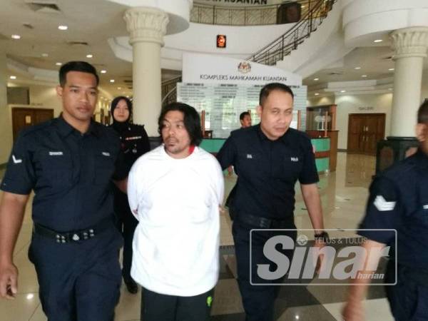 Tertuduh kelihatan tenang ketika diiringi anggota polis keluar dari mahkamah hari ini.