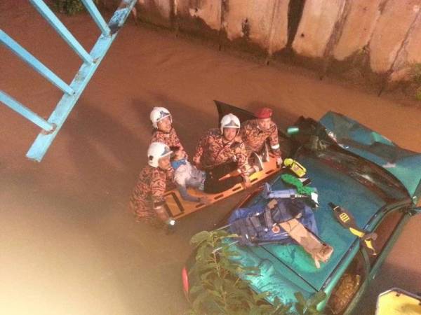 Pasukan bomba turun ke bawah bagi mengeluarkan mangsa yang terperangkap dalam kereta selepas kemalangan di Jalan Semarak awal pagi tadi. - Foto JBPMKL