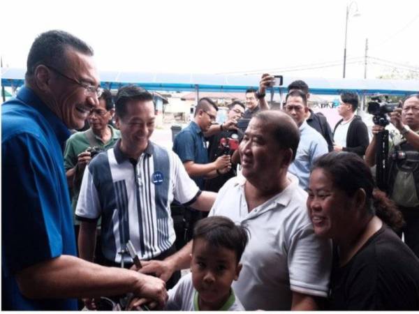 Hishammudin (kiri) beramah mesra dengan komuniti nelayan Serkat, Pontian pagi tadi.