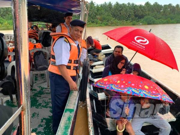 Muhammad Nur Syam (Kiri) sempat menyantuni penduduk kampung yang menggunakan bot di kawasan Teluk Renjuna.