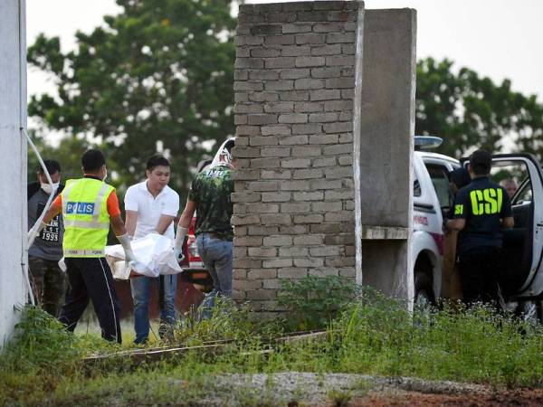 Anggota polis mengangkat mayat Mohd Faez Mohd Jefri, 28, yang dijumpai di tapak bauksit belakang petrol pam Petron Jalan Pintasan Kuantan-Kemaman, hari ini- Foto Bernama