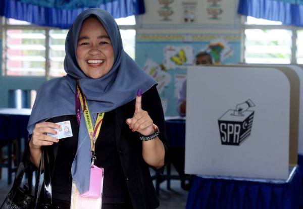 Najihah menjalankan tanggungjawab sebagai pengundi kira-kira jam 8.10 pagi tadi di Sekolah Kebangsaan Pengkalan Raja. - Foto: Bernama