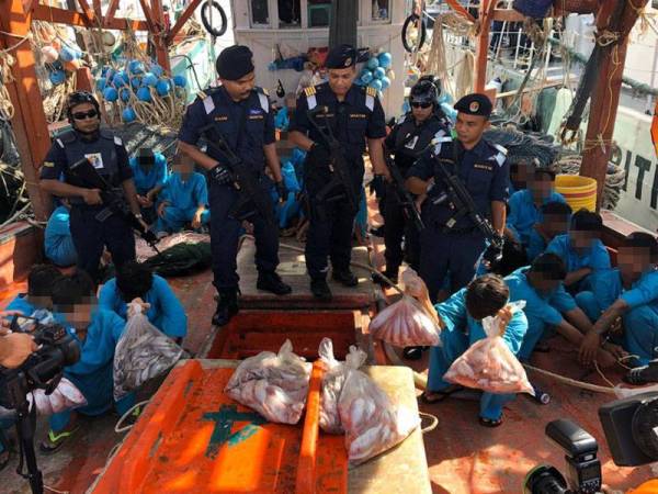 Muhammad Nur Syam (tengah) melihat tempat penyimpanan ikan dalam bot tersebut.