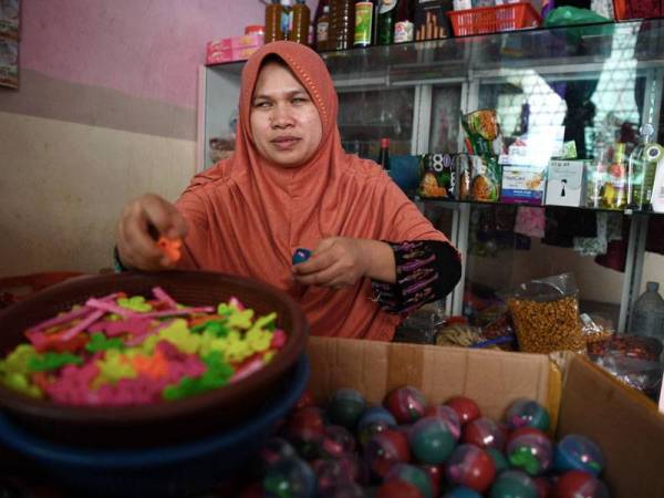 Malikah Cholil, 38, ibu tunggal cacat penglihatan membanting tulang empat keratnya dengan melakukan empat jenis kerja demi kelangsungan hidup. - Foto Bernama