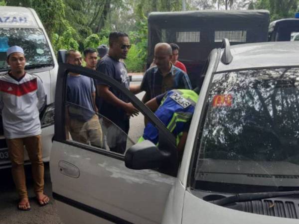 Anggota polis memeriksa keadaan mayat berkenaan yang ditemukan dalam sebuah kereta. Foto: Ihsan IPD Kuala Langat