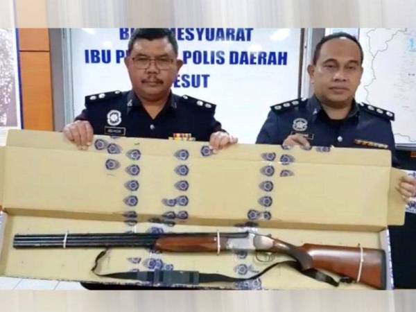 Abdul Rozak (kiri) menunjukkan senapang patah yang dirampas.