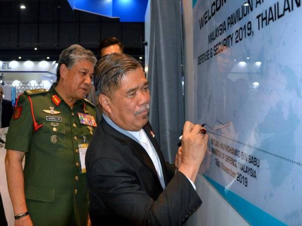 Mohamad Sabu (kanan) menandatangani plak sempena perasmian Pavilion Malaysia di Pameran Defence & Security 2019 di Pusat Pameran dan Konvensyen IMPACT di Nonthaburi hari ini. - Foto Bernama