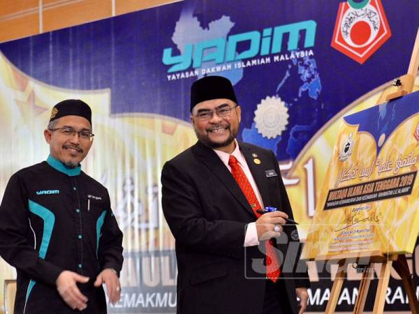 Mujahid (dua dari kiri) menandatangani plak sebagai simbolik perasmian Multaqa Ulama Asia Tenggara 2019 sambil diperhatikan oleh Nik Omar di MHCC KLIA, Sepang hari ini. - FOTO ZAHID IZZANI