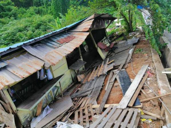 Keadaan kedai yang telah menggelongsor ke belakang akibat tanah runtuh di Jalan Mutiara Emas 5/15 Taman Mount Austin di sini pagi tadi.