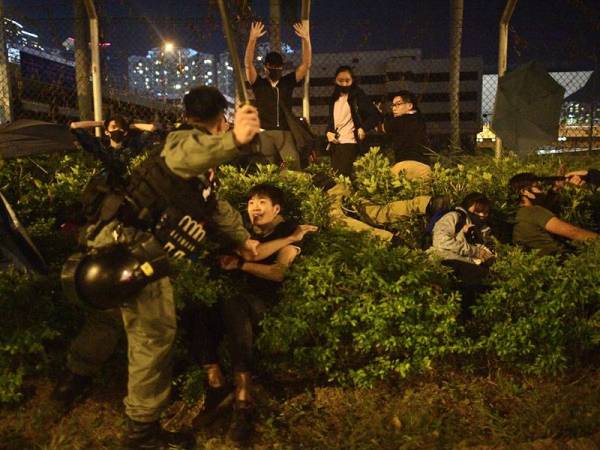 Polis menahan penunjuk perasaan yang cuba melarikan diri dari kampus Universiti Politeknik Hong Kong (PolyU) di daerah Hung Hom semalam. - Foto: AFP