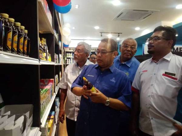 Abdul Fattah (depan) melihat produk yang disediakan di farmasi tersebut sempena perasmian outlet coop farmasi di Bentong semalam.