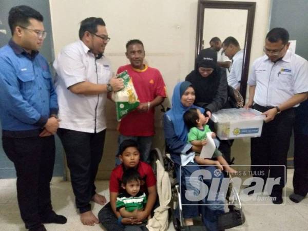 Mohd Aqmal (kanan) menyerahkan sumbangan barangan keperluan harian kepada seorang penerima zakat LZS pada Program Ziarah Agensi Lembaga Zakat Selangor bersama Tenaga Nasional Berhad (TNB) Cawangan Cheras di daerah Hulu Langat di sini hari ini.