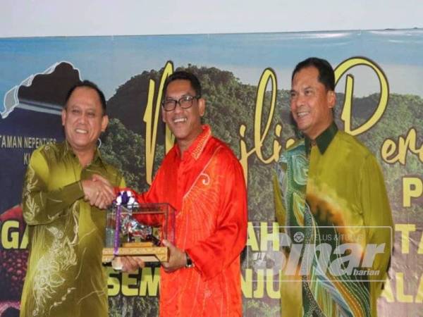 Ahmad Faizal (tengah) menerima cenderahati daripada Pengarah Perhutanan Perak, Datuk Mohamed Zin Yusop selepas merasmikan Persidangan Pengarah-Pengarah Perhutanan Negeri Semenanjung Malaysia ke-39 dan Pelancaran Program 'Perak Oxygen-Land Bank' hari ini.