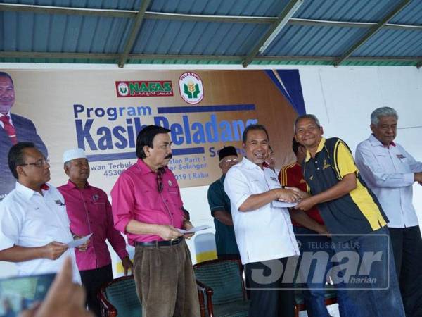 Yaakob (tiga dari kanan) menyampaikan sumbangan zakat kepada penerima pada Program Kasih Peladang Selangor di Dewan Terbuka Parit 1, Jalan Parit 1, Sungai Besar, Selangor semalam.