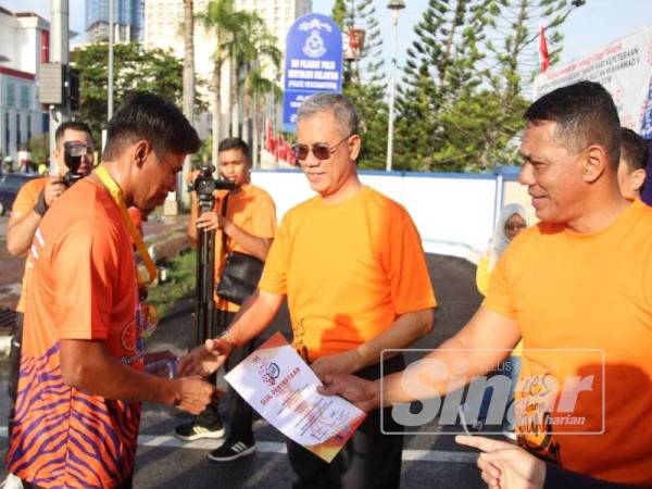 Hasanuddin menyampaikan sijil penyertaan kepada mereka yang menjayakan Larian Oren 'Gojes Orange Fun' di sini hari ini.