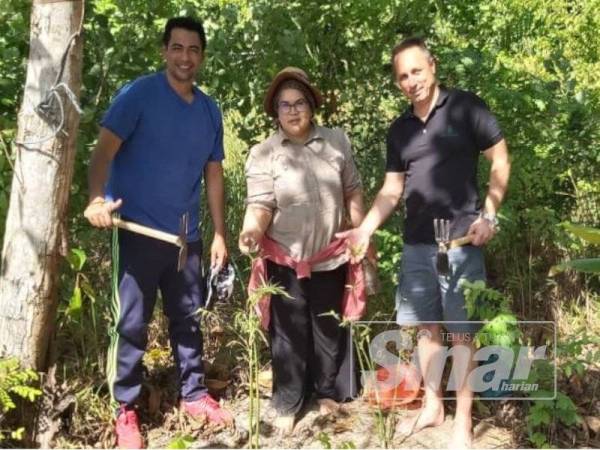 Sheikh Muszaphar (kiri) dan Anton Nikolaevich Shkaplerov (kanan) menanam pokok kelapa di tepi pantai.