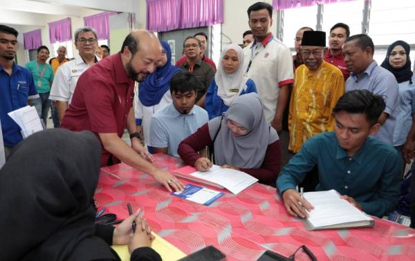 Mukhriz meninjau ruang pameran Karnival Pendidikan, Kerjaya dan Keusahawanan Parlimen Jerlun di Sekolah Menengah Kebangsaan (SMK) Agama Jerlun hari ini.